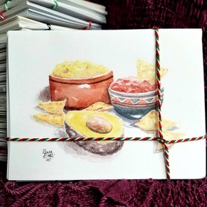 May include: Watercolor painting of a bowl of guacamole, a bowl of salsa, and tortilla chips. The guacamole is in a brown bowl, the salsa is in a blue and white bowl, and the chips are scattered around the bowls. The painting is signed "Kena P. 2017".
