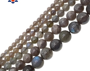 May include: A strand of round, gray labradorite gemstone beads. The beads are smooth and polished, with a slight iridescent sheen.