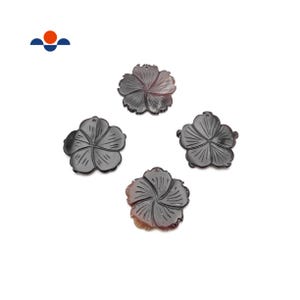 May include: Four dark gray flower-shaped pendants with carved details. Each pendant has a hole at the top for stringing. The pendants are arranged on a white background. The pendants are likely for jewelry making.