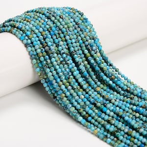 May include: Strands of turquoise gemstone beads. The beads are small, round, and faceted, displaying a range of blue and green hues. The beads are strung together, creating a flowing, textured appearance. Ideal for jewelry making.