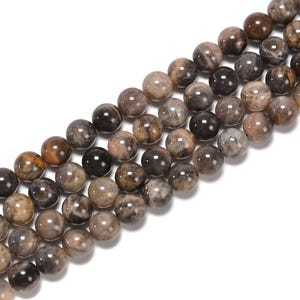 May include: Strands of round, polished gemstone beads in varying shades of brown, gray, and black. The beads have a smooth, glossy finish and are strung together, ready for jewelry making or crafting projects.