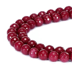 May include: A strand of faceted, deep red gemstone beads. The beads are round with multiple facets, creating a sparkling effect. The color is a rich, dark red, and the beads are strung together, ready for jewelry making. The background is white.