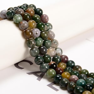 May include: A strand of green, brown, and gray agate beads. The beads are round and have a natural, polished finish.