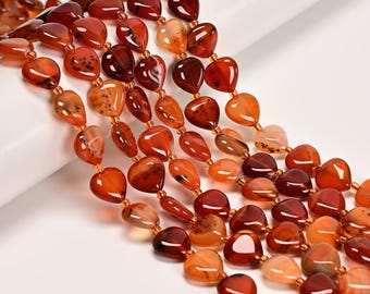 May include: Strands of heart-shaped beads in shades of red, orange, and brown. The beads are strung together, creating a cascading effect. The beads have a glossy finish and vary in size and color intensity.
