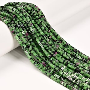 May include: Strands of square-cut beads in shades of green, black, and red. The beads are strung together, creating a flowing, textured appearance. The beads are likely made of a natural stone, such as ruby zoisite, and are suitable for jewelry making.