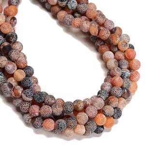 May include: Strands of round, natural stone beads in shades of brown, orange, and black. The beads have a cracked, web-like pattern. The beads are strung together, likely for jewelry making or crafting.