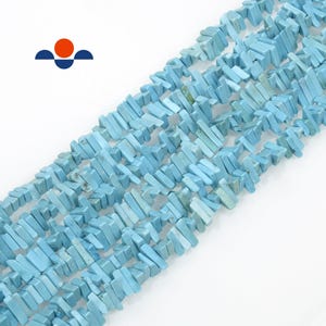 May include: Strands of light blue, rectangular turquoise beads. The beads are strung together, creating a textured surface. The beads are a consistent size and shape, with a slightly irregular surface. The background is white.