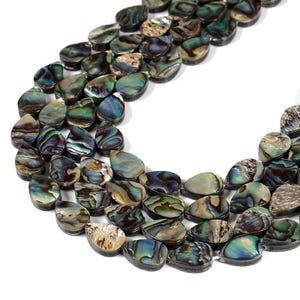 May include: Close-up of a collection of iridescent abalone shell beads. The teardrop-shaped beads display a range of colors, including blues, greens, and browns, with a shimmering, pearlescent effect. These beads are ideal for jewelry making.