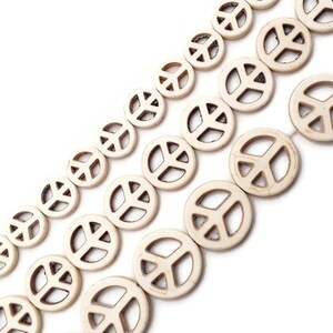 May include: Off-white peace sign beads in various sizes, strung together in diagonal rows against a white background. The beads have a circular shape with the peace symbol cut out in the center. Ideal for jewelry making.