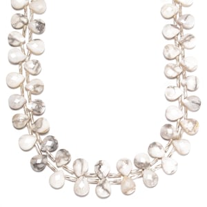 May include: Two strands of white and gray gemstone beads. The teardrop-shaped beads are strung on a silver-colored wire. The beads have a faceted surface and a marbled appearance, with gray veining throughout the white stone.
