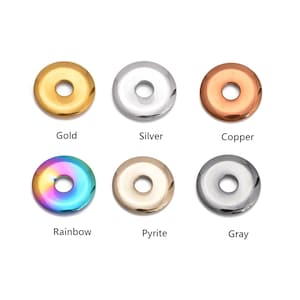 May include: Six metal disc beads in gold, silver, copper, rainbow, pyrite, and gray. Each bead has a central hole. The colors are labeled below each bead.
