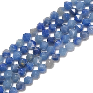 May include: Strands of faceted blue gemstone beads in varying shades of blue. The beads have a geometric shape and are strung together, creating a textured and colorful display. Ideal for jewelry making.
