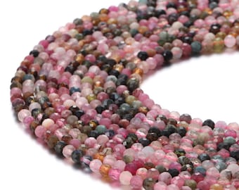 May include: A strand of multi-colored round gemstone beads. The beads are a mix of pink, green, blue, and brown. The beads are faceted and have a shiny finish.