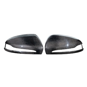 May include: A pair of black carbon fiber side view mirror covers for a car.