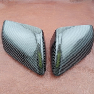 May include: A pair of black carbon fiber side view mirrors for a car.