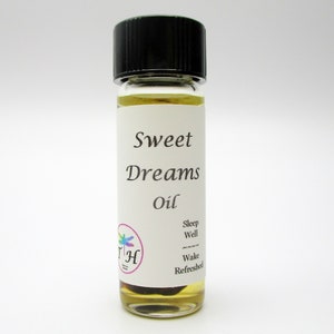 Op de afbeelding: Een klein glazen flesje met een zwarte dop gevuld met een heldere vloeistof. Het etiket vermeldt "Sweet Dreams Oil" met de tekst "Sleep Well, Wake Refreshed" eronder.