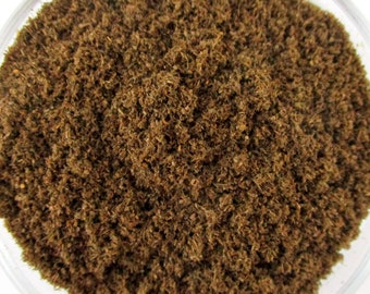 May include: Close-up of a brown, finely ground powder. The powder is made of dried herbs and spices.