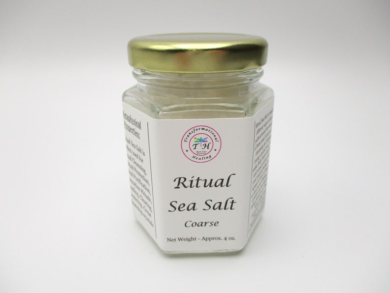 May include: A glass jar with a gold lid filled with white coarse sea salt. The label reads "Ritual Sea Salt Coarse" and "Net Weight - Approx. 4 oz."