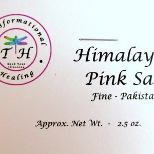 May include: A white label with a pink circle containing a dragonfly and the text "Transformational TH Shed Your Illusions Healing". The label also has the text "Himalayan Pink Salt Fine - Pakistan Approx. Net Wt. - 2.5 oz."