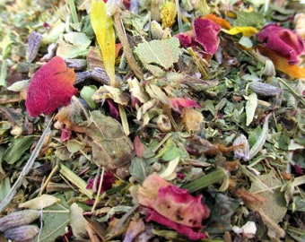 May include: A close-up of a blend of dried herbs and flowers, including green leaves, lavender buds, rose petals, and yellow petals.