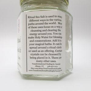 May include: A glass jar filled with white sea salt. The label reads "Ritual Sea Salt is used in many different ways in the various paths around the world. Most of these uses focus on a way of cleansing and clearing the energy around you. You can make Holy Water for blessings and consecrations. Add it to your magical baths. It can be spread around a ritual circle or used as an offering. Certain crystals can be cleansed by being placed in it. There are many other uses. Transformational Healing by Dawna Albany, NY 518-577-7171 Etsy.com/shop/DeesTransform Healing www.Transformational Healingby Dawna.com"