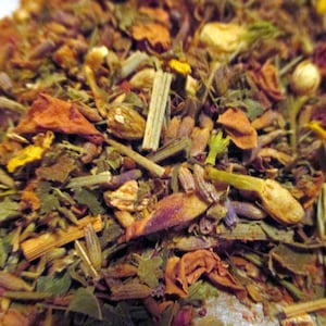 May include: A close-up of a blend of dried herbs and flowers, including lavender, rose petals, and other botanicals. The mixture is a variety of colors, including purple, pink, orange, and green.