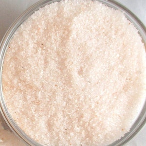 May include: Close-up view of fine-grained pink Himalayan salt in a clear glass jar.
