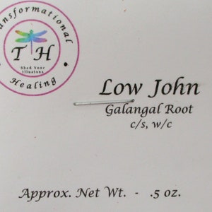 May include: A white label with black text that reads "Low John Galangal Root c/s, w/c Approx. Net Wt. - .5 oz.". A small, round, pink sticker with a dragonfly and the text "Transformational TH Shed Your Illusions Healing" is in the upper left corner.