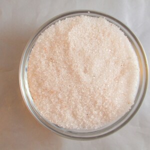 May include: A glass bowl filled with fine-grained pink Himalayan salt.