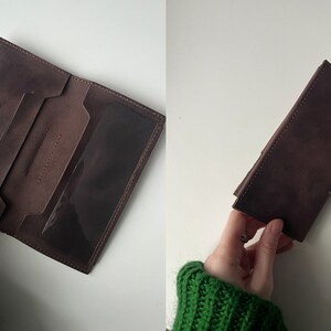 Puede incluir: Una cartera de cuero marrón con múltiples ranuras para tarjetas y una ventana de plástico transparente para el DNI. La cartera está doblada por la mitad y el interior es visible.