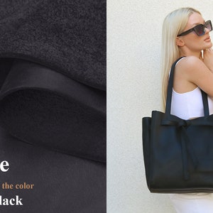 May include: Large black leather tote bag with a bow detail. In this photo, the color is Matte Black.