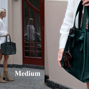Puede incluir: Dos mujeres llevan bolsos de mano de cuero verde y negro. Los bolsos son de tama&ntilde;o mediano y tienen una correa de cuero marr&oacute;n con un peque&ntilde;o amuleto de oso. La palabra "Medium" est&aacute; impresa en la parte inferior de la imagen.