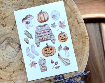 May include: A white card with watercolor illustrations of fall-themed items, including pumpkins, gourds, mushrooms, leaves, a sweater, and a cup of coffee.