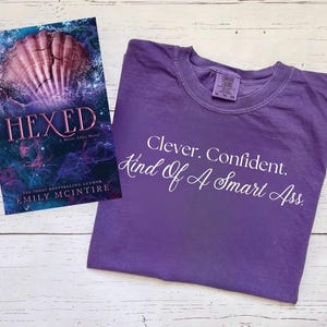 エミリー・マッキンタイアのライセンス商品「Hexed By Emily McIntire」シャツ、Never Afterシリーズ、Sea Wheel Atlantic Cove、In My Mermaid Era、The Lair、Hooked、Hexed、Scarred