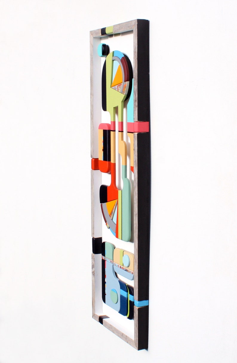 Puede incluir: Una pieza de arte de pared abstracta colorida con formas geom&eacute;tricas y patrones en un marco de madera. La obra de arte presenta una variedad de colores, incluyendo rojo, naranja, amarillo, verde, azul y negro.