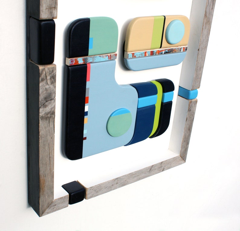 Puede incluir: Arte de pared geom&eacute;trico abstracto hecho de madera con un esquema de color azul, verde, amarillo y negro. El arte est&aacute; enmarcado en un marco de madera r&uacute;stico.