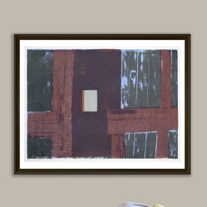 May include: A framed abstract art print with geometric shapes in shades of brown, green, and blue. The print is hanging on a light beige wall above a red cabinet with a yellow pitcher and bowl.