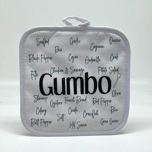 May include: White cotton pot holder with the word "Gumbo" printed in black in the center. Surrounding the word are various ingredients used in Gumbo, such as seafood, roux, garlic, cayenne, onions, black pepper, Cajun, andouille, crab, file, chicken & sausage, potato salad, shrimp, oysters, French bread, red pepper, okra, celery, salt, Creole, crawfish, rice, bell pepper, hot sauce, and green onions.