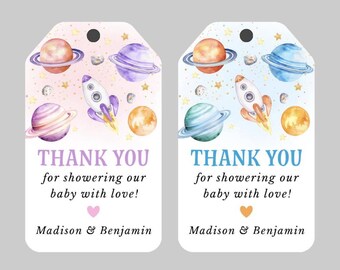 May include: Two rectangular gift tags with rounded tops and punched holes, featuring watercolor space illustrations of planets, stars, and a rocket. The text reads: THANK YOU for showering our baby with love! Madison & Benjamin, with a small heart icon.