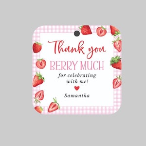 May include: A square tag with a pink gingham border and watercolor strawberries. The text reads "Thank you BERRY MUCH for celebrating with me!" and "Samantha" in a handwritten style font.