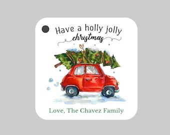 May include: Red car with a Christmas tree on top, driving through a snowy scene. The text "Have a holly jolly christmas" is above the car and "Love, The Chavez Family" is below the car.