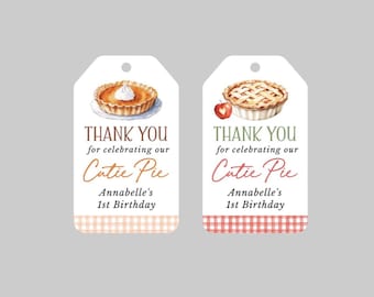 Può includere: Due etichette regalo rettangolari bianche con angoli superiori arrotondati e un foro per appenderle. L'etichetta sinistra presenta un'illustrazione di torta di zucca, quella destra una torta di mele e una piccola mela. Entrambe riportano il testo: THANK YOU for celebrating our Cutie Pie Annabelle's 1st Birthday, con un motivo a quadretti sul fondo.