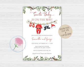 May include: A white baby shower invitation card featuring watercolor greenery and red berries at the top and bottom. The text reads Santa Baby IS ON THE WAY! with illustrations of red mittens, a red baby onesie, black boots, and a Santa hat on a string.