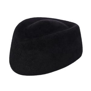K&ouml;nnte beinhalten: Ein schwarzer Filzhut im Fedora-Stil mit abgerundeter Krone und breiter Krempe.