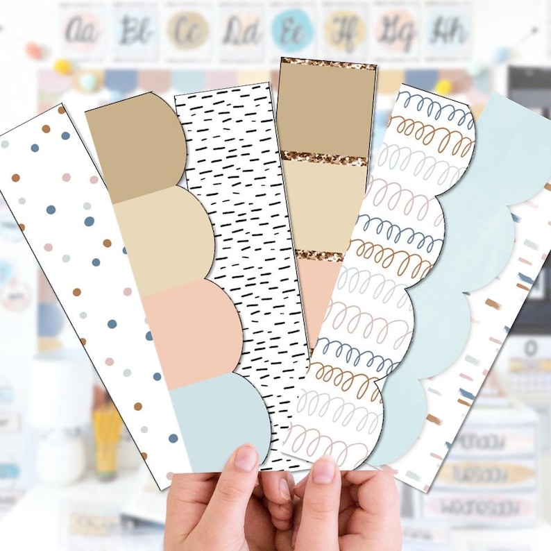 May include: A collection of five decorative bookmarks with various patterns and colors. The designs include polka dots, scalloped edges, abstract lines, and gold glitter accents. The color palette features beige, pink, blue, and black. The bookmarks are held in a person's hands.