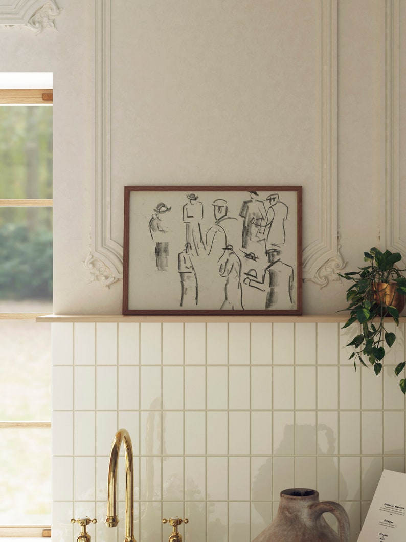 Op de afbeelding: Een ingelijste zwart-wit schets van mensen in een groep. De schets is in een bruin frame en hangt aan een witte betegelde muur.