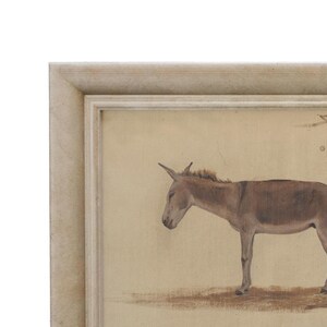 May include: A framed print of a brown donkey standing on a beige background. The donkey is facing left and has its head lowered. The frame is a light gray color.