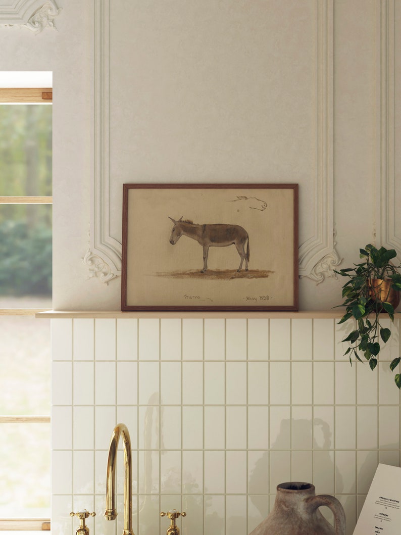 Puede incluir: Una ilustraci&oacute;n vintage enmarcada de un burro marr&oacute;n con el texto "Esel" y "Muny H.B." debajo de la imagen. El marco es de madera marr&oacute;n y la imagen est&aacute; en una pared de azulejos blancos.