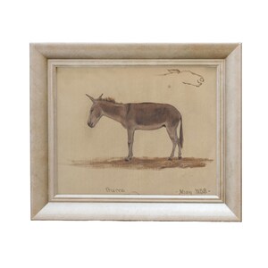 May include: A framed drawing of a donkey in a light silver frame. The drawing is in brown and black ink on a cream-colored paper. The drawing is signed "Bruno" and dated "May 1858".