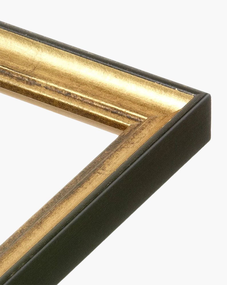 Puede incluir: Primer plano de un marco de imagen con un exterior de madera negra y un borde interior dorado.